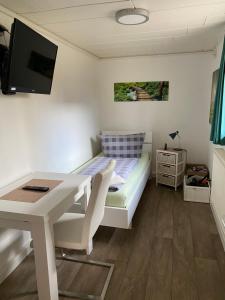 a small room with a table and a bed at C&C Gästehaus Bückeburg in Bückeburg