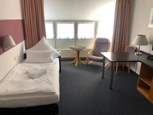 een hotelkamer met een bed, een bureau en stoelen bij Apartment 31 in Sindelfingen