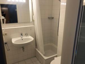 een witte badkamer met een wastafel en een douche bij Apartment 31 in Sindelfingen