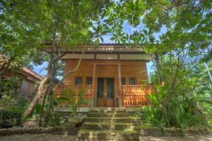 ein Holzhaus mit einer Treppe davor in der Unterkunft Bata Merah Homestay in Banyuwangi