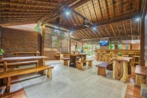 ein Restaurant mit Holztischen und Holzbänken in der Unterkunft Bata Merah Homestay in Banyuwangi