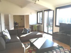 Una sala de estar con un sofá y un televisor de pantalla plana. en maison Moliere, en Aix-en-Provence