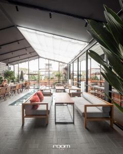 a large building with tables and chairs and windows at Luk Hostel in Bangkok