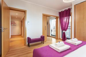 a bedroom with two beds and a purple chair at Privilege Apartment Galichet with Rooftop Pool, Village Marina - Olhão in Olhão +15 photos