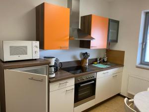 a kitchen with a microwave and a stove top oven at Gaststätte Brandenburg in Nordhausen