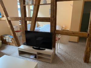 een televisie op een standaard in een kamer met een bed bij Gaststätte Brandenburg in Nordhausen