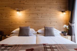 two beds in a room with wooden walls at Chalet Bellavista in Livigno