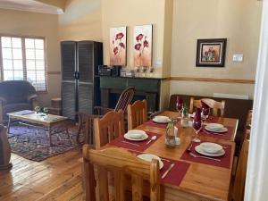 a dining room with a table and chairs and a fireplace at Jungnickel Guesthouse in Kimberley