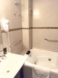 La salle de bains est pourvue d'une baignoire, d'un lavabo, de toilettes et d'une douche. dans l'établissement Andaluhe Posada, à Miramar