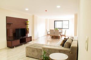 a living room with a couch and a dining room at Apartamento amplio y acogedor en Ciudad del Este in Ciudad del Este