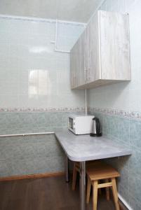 a small kitchen with a table with a microwave at Apartments on Yavornitsky av. in Dnipro