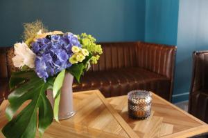 un vase rempli de fleurs violettes et jaunes sur une table dans l'établissement Hotel de Champagne, à Épernay