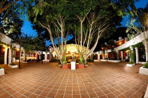 a courtyard at night with trees and a building at Belcekiz Beach Club - All Inclusive in Oludeniz