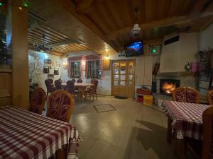 a dining room with a table and chairs and a fireplace at Guest House Vila Djokic in Zlatibor