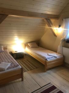 um quarto com 2 camas num sótão em Siedlisko Błominko em Rzeck