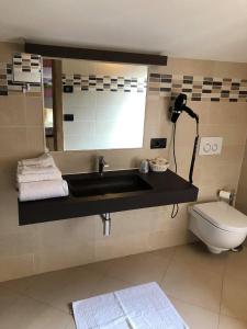 a bathroom with a sink and a toilet at Hotel Berlinghera in Sorico