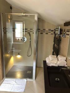 a bathroom with a shower and a sink with towels at Hotel Berlinghera in Sorico