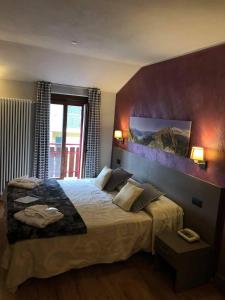 a bedroom with a bed and a painting on the wall at Hotel Berlinghera in Sorico