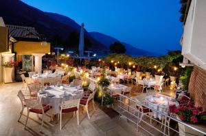 a restaurant with tables and chairs on a balcony at night at Belcekiz Beach Club - All Inclusive in Oludeniz