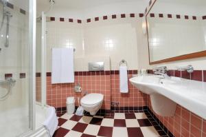 a bathroom with a toilet and two sinks and a shower at Belcekiz Beach Club - All Inclusive in Oludeniz