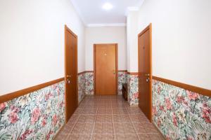 a hallway with two doors and floral wallpaper at Gloria Park Hotel in Koreiz