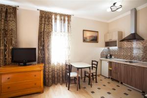 cocina con mesa y TV en una habitación en Gloria Park Hotel, en Koreiz