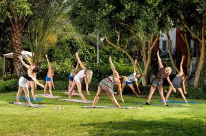 a group of people doing yoga in the grass at Belcekiz Beach Club - All Inclusive in Oludeniz
