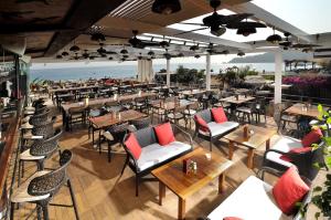 a restaurant with tables and chairs and the ocean at Belcekiz Beach Club - All Inclusive in Oludeniz