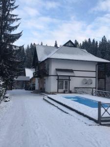 uma casa com piscina na neve em Готель RIVER HILL em Mykulychyn