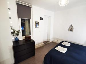 1 dormitorio con 1 cama azul y vestidor negro en Au Bretzel Doré - Centre Historique, en Colmar