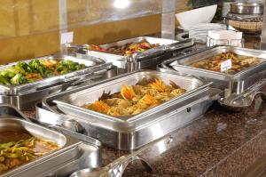 a buffet line with many trays of different foods at Belcekiz Beach Club - All Inclusive in Oludeniz