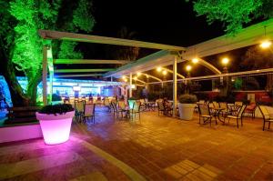 a patio with chairs and tables at night at Belcekiz Beach Club - All Inclusive in Oludeniz