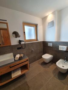 a bathroom with a toilet and a sink at Hotel Andechserhof & Mountain Sky in Laion