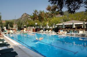 a large swimming pool with people in the water at Belcekiz Beach Club - All Inclusive in Oludeniz
