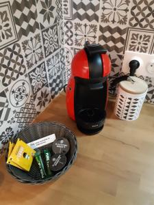 a red coffee pot sitting next to a basket of food at Studio hyper centre avec balcon in Châteauroux