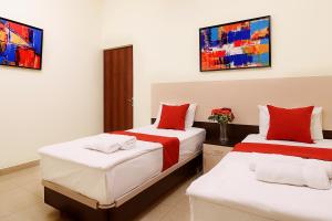 a bedroom with two beds with red and white sheets at Apartments in Alley Residence in Yerevan