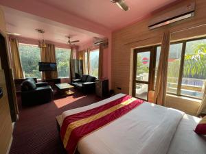 a bedroom with a large bed and a living room at Chanakya Resort in Rishīkesh