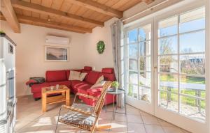 DithmarschenにあるNice Home In Dithmarschen With Wifiの赤いソファと大きな窓のあるリビングルーム