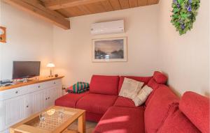 uma sala de estar com um sofá vermelho e uma televisão em Lovely Home In Dithmarschen With Kitchen 