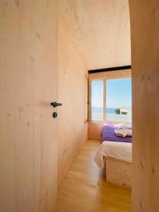 a small bedroom with a bed and a window at Ecobeachvilla Buqez 9 in Pakoštane