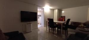 a living room with a table and a television on a wall at 74 Pijnboomstraat in The Hague