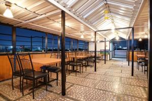 a dining area with tables and chairs in a building at Hotel Gayathri in Hyderabad