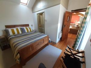 a bedroom with a bed and a chair in it at Bryn Teg Barn in Dyffryn