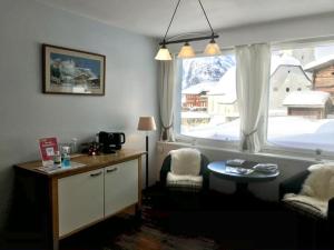 ein Wohnzimmer mit einem Tisch und einem großen Fenster in der Unterkunft Hotel Wannenhorn in Bellwald