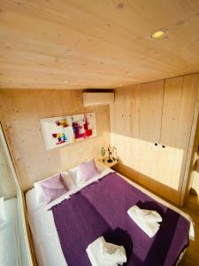 a bedroom with a purple bed in a room at Ecobeachvilla Buqez 9 in Pakoštane