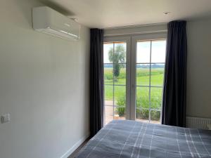una camera con un letto e una grande finestra di Hof van Lenthe appartement De Mars a Dalfsen