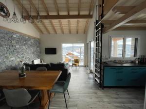 - un salon avec une table et une salle à manger dans l'établissement le bleu du lac Sauna et Spa, à Gérardmer