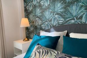 1 dormitorio con cama con almohadas azules y papel pintado en Oasis Sun Beach Costa del Sol, en Estepona