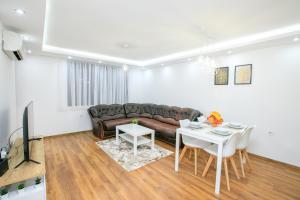uma sala de estar com um sofá e uma mesa em Dream Park Apartment em Sandanski