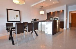 una cucina e una sala da pranzo con tavolo e sedie di Fantastic sea view apartment! a Portstewart